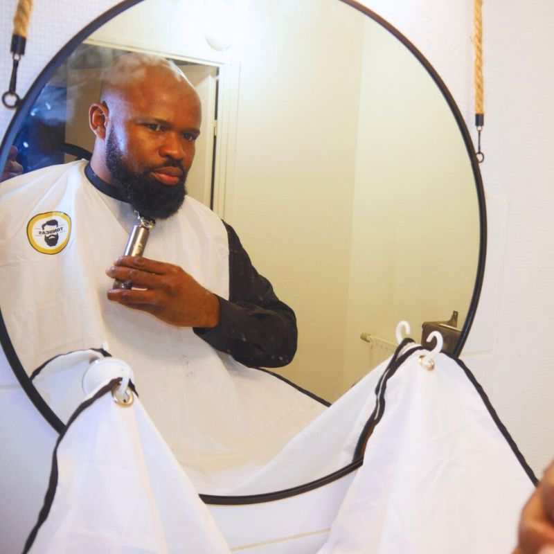 un modèle utilise le  Tablier barbe- tondeas/ bavoir à barbe de qualité
