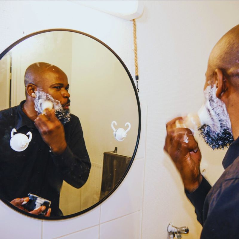 UN modèle utilise le savon pour rasage  /un homme joyeux avec son savon de rasage bio