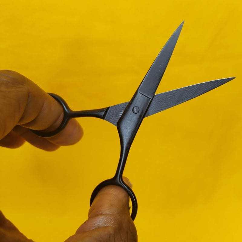 un homme tiens ciseaux à barbe
